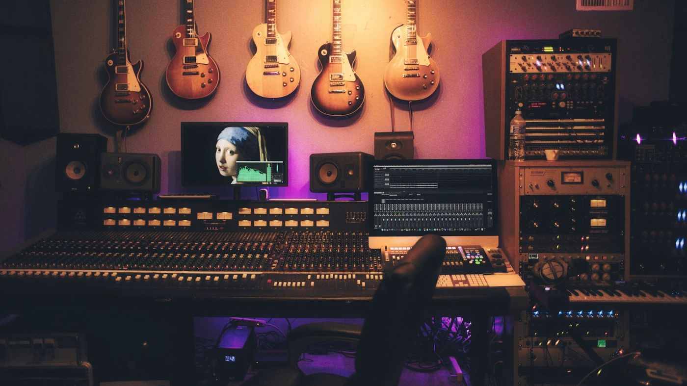 Recording studio at night — figure working at a mixing console under warm lamplight